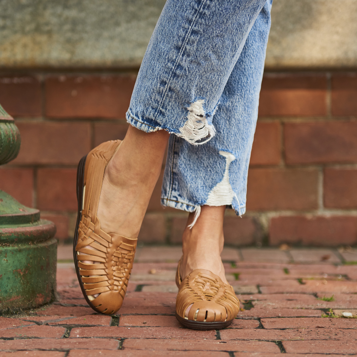 A woman wearing the Trinidad huarache sandal in Natural (Tan).