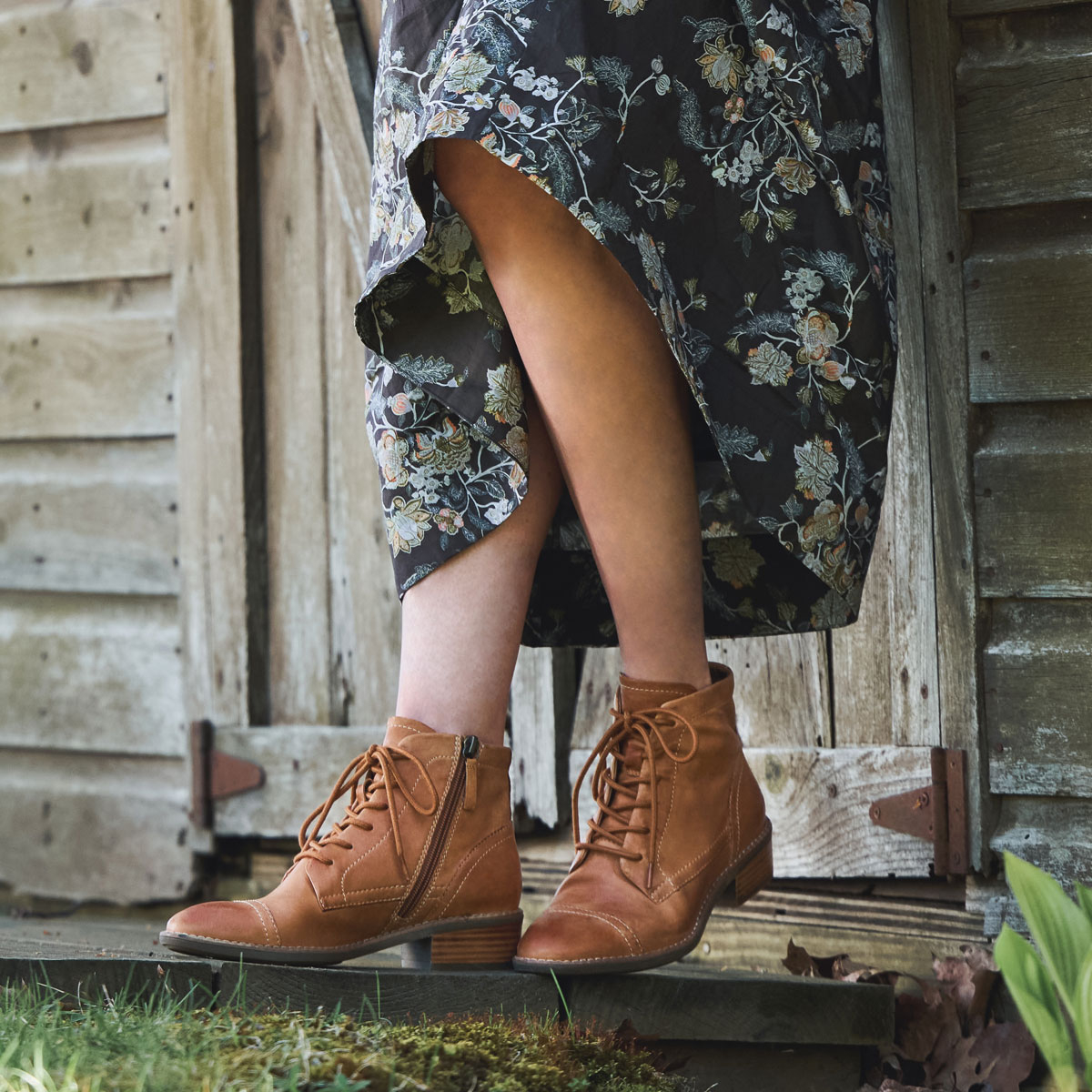 A woman wearing the Cordia lace-up side-zip bootie in honey (tan).