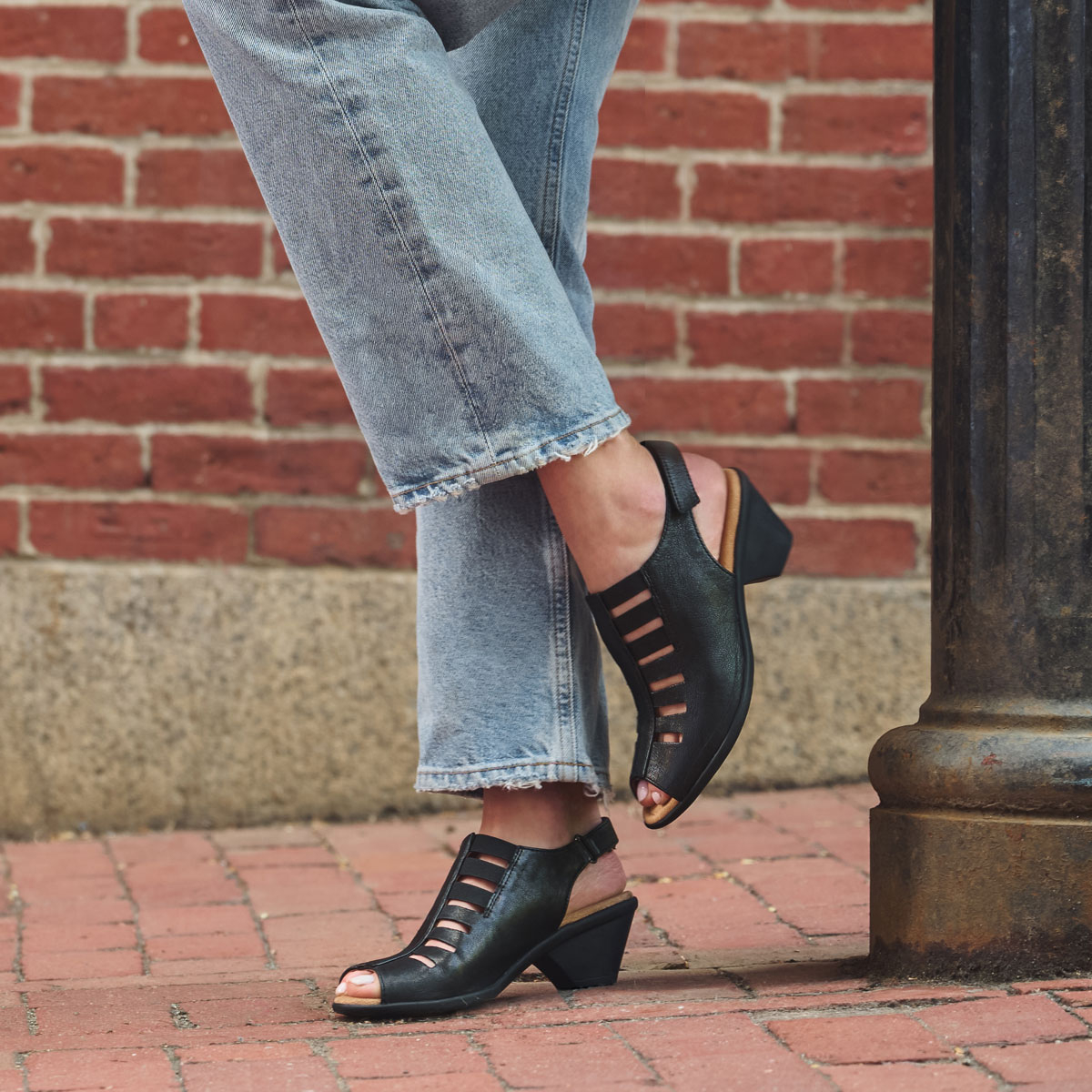 A woman wearing the Faye Heeled Sandal in black.