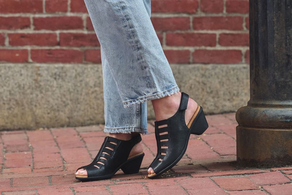 A woman wearing the Faye Heeled Sandal in Black Nubuck.