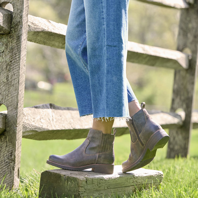 A woman wearing the Claire bootie in brown.
