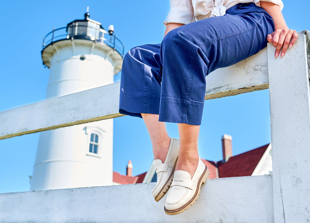 A woman wearing the the Lakota loafer in white.