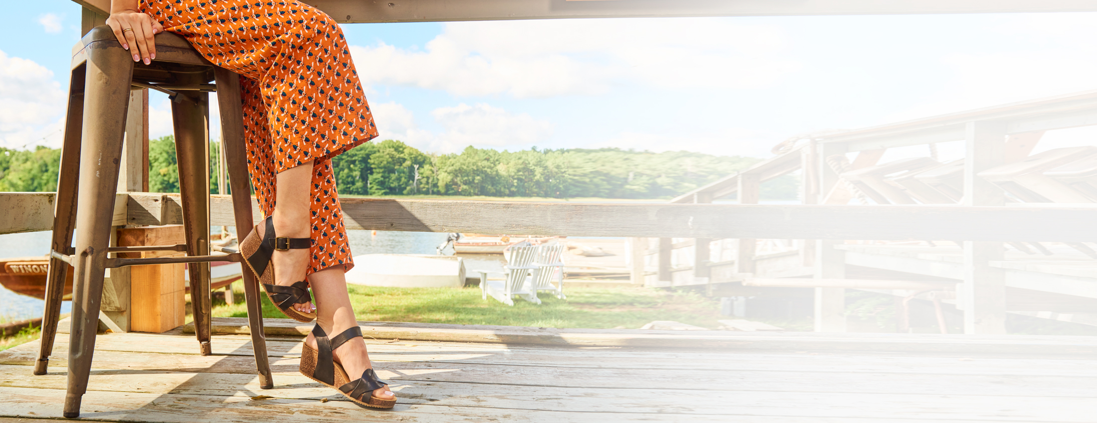 A woman wearing the Erena wedge sandal in Black.