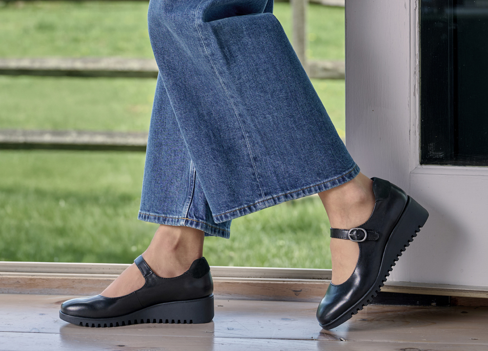 A woman wearing the Debbie wedge mary jane in black.