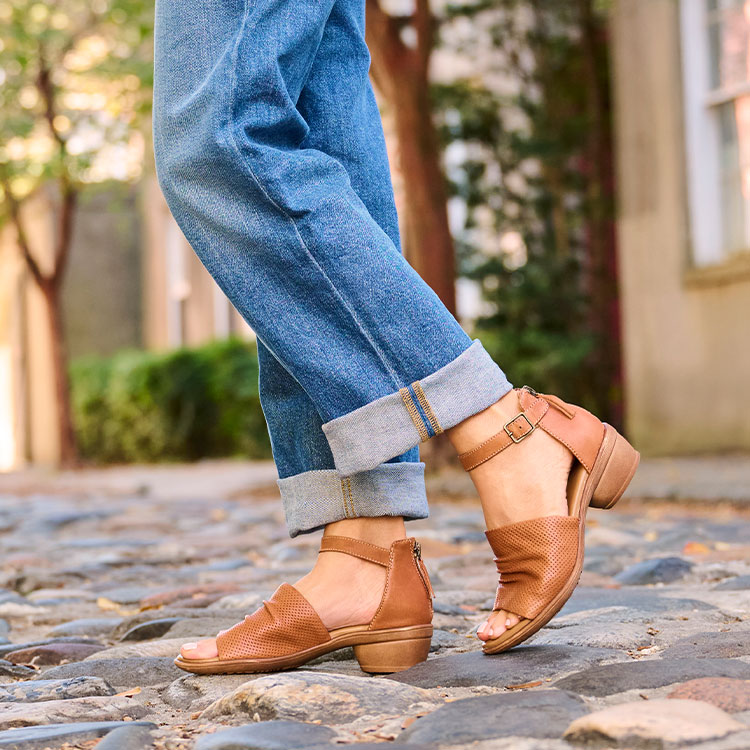 A woman wearing the Newnan heeled sandal in tan.