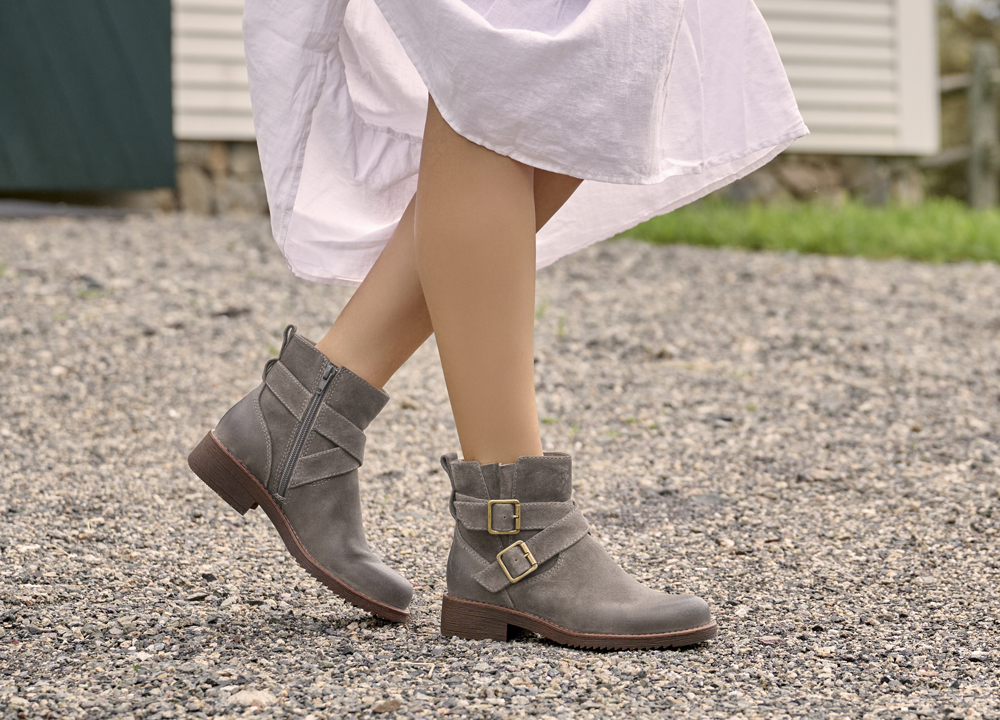 A woman wearing the Clover ankle boot in Light grey suede.